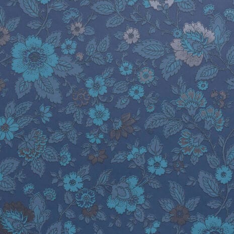 Tapetissa on tummia, petroolin- ja harmaansinisen sävyisiä kukkia tummansinisellä taustalla.